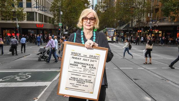 Proud and passionate: activist Jean McLean, pictured in Collins Street, holds a poster for a Wreck the Draft event from her anti-Vietnam War conscription protest days.