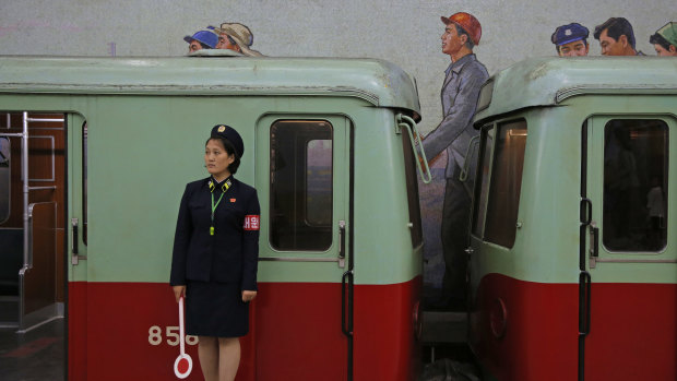 A North Korean subway officer stands next to a train in a subway station in Pyongyang.