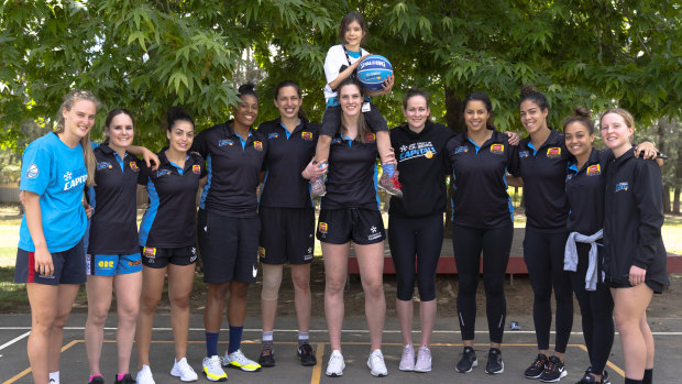 Daliah Lee (on the shoulders of Lauren Scherf) meets hers favourite team - the UC Canberra Capitals.
