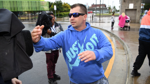 A supporter of Brae Taylor Lewis hurls abuse at a television cameraman outside court.