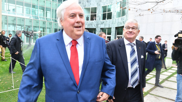 Businessman Clive Palmer 
and senator Brian Burston leave their press conference after it was interrupted when the sprinklers. came on  