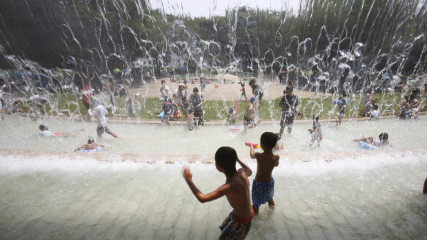 Children play in a Tokyo park on Monday as the mercury reached 35 degrees.