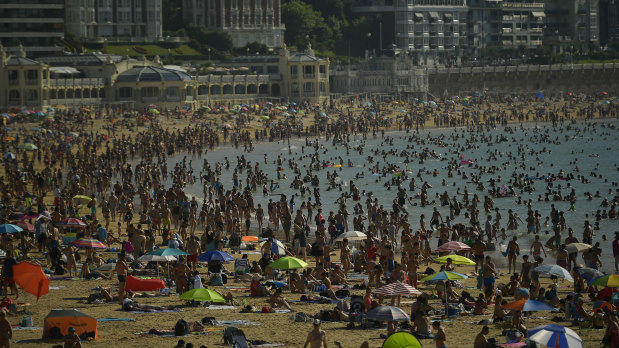 Huge crowds swarm beaches in San Sebastian, northern Spain, during the country's heatwave.