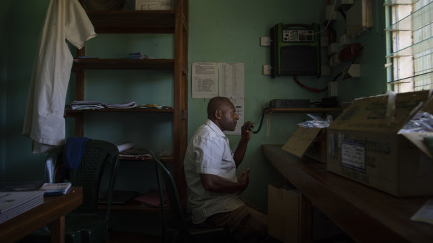 Mougulu health worker Jamie Gubego assists a woman in labour over a two-way radio.