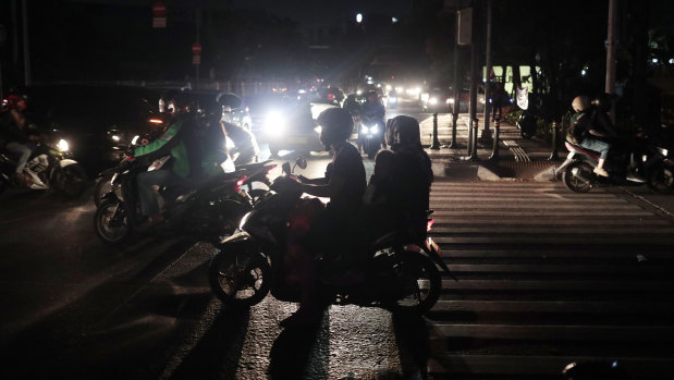Motorists navigate through traffic during a power outage in Jakarta.