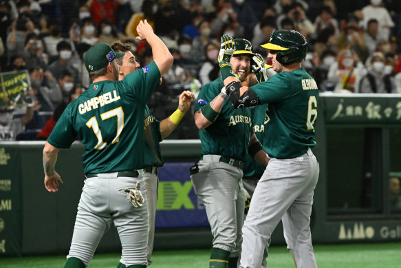 Robbie Glendinning celebrates with teammates after hitting a three-run home run to make it 5-4.