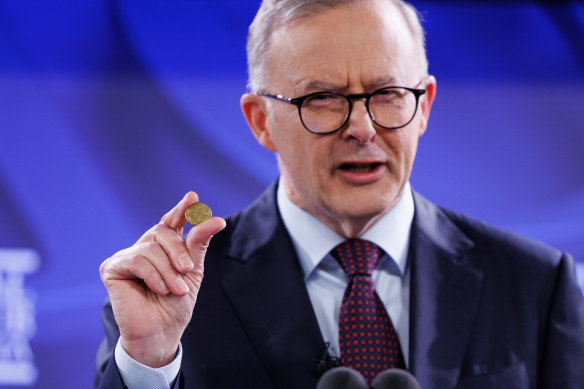 Anthony Albanese holds up a $1 coin during an address to the National Press Club in Canberra last month.