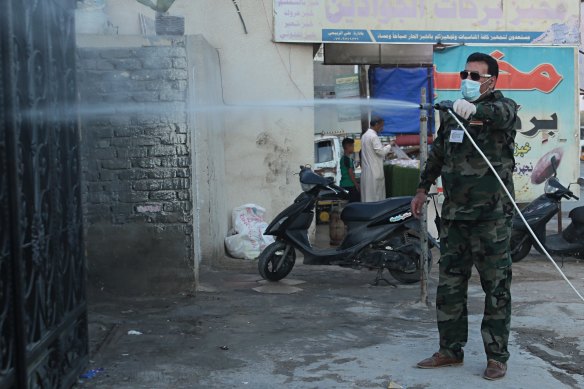 A civil defence worker sprays disinfectant as a precaution against the coronavirus in Baghdad.