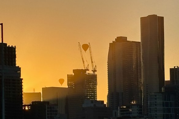 Two hot air balloons travel through the smoky haze blanketing the city skyline ahead of a forecast temperature of 45 degrees in Melbourne today. 