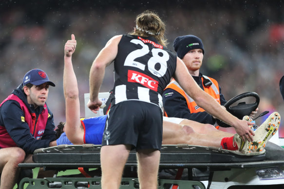 Collingwood defender Nathan Murphy comforts Angus Brayshaw as he leaves the ground after being tackled in the qualifying final.