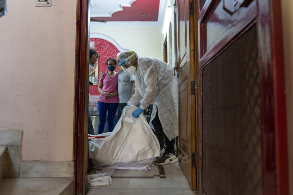 Health workers from the United Sikhs’ ambulance service make preparations for moving a body to a crematorium  in New Delhi on Tuesday.