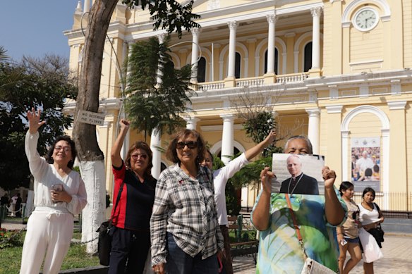 Faithful hold a photo of Pope Leo in front of the Cathedral of Chiclayo, Peru, where he served as bishop for several years.