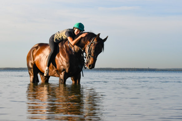 Jess Bott leans down the neck of Hawaii Five Oh and gives him a pat in Botany Bay on Monday.