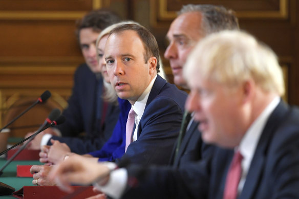 British Health Secretary Matt Hancock, centre, attends a cabinet meeting with Prime Minister Boris Johnson, right, and others.