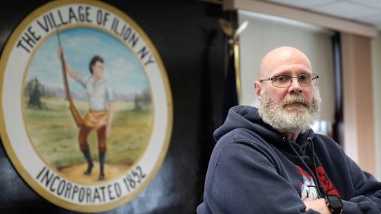 Ilion Mayor John Stephens poses for a picture in front of the seal of the village 