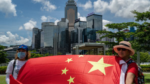 Pro-Beijing supporters in Hong Kong wave a Chinese flag and sing the national anthem in celebration of the passing of the new national security law on Tuesday.