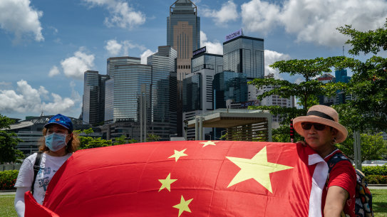 Pro-Beijing supporters in Hong Kong wave a Chinese flag and sing the national anthem in celebration of the passing of the new national security law on Tuesday.
