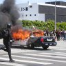 A police car burns during protests in Los Angeles.