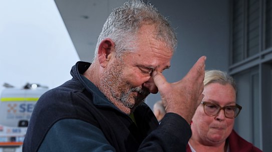 Paul Brennan (left) becomes emotional after being rescued from their Oxley Island home.