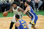 Boston Celtics guard Marcus Smart prepares to drive against Golden State Warriors star Stephen Curry.