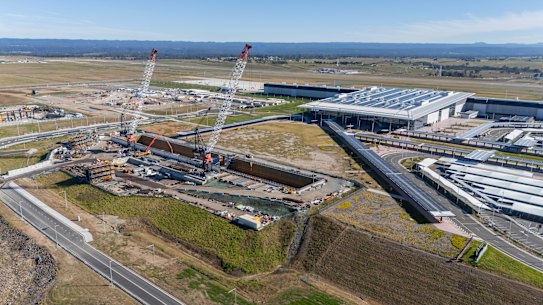 Guindastes erguem-se acima de um buraco retangular gigante cavado para a estação terminal do Aeroporto de Western Sydney.