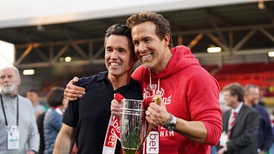 WREXHAM, WALES - APRIL 26: Rob McElhenney and Ryan Reynolds, co-owners of Wrexham AFC, pose for a photo with the trophy following the club’s promotion to the Sky Bet Championship during the Sky Bet League One match between Wrexham AFC and Charlton Athletic FC at Racecourse Ground on April 26, 2025 in Wrexham, Wales. (Photo by Kya Banasko/Getty Images)