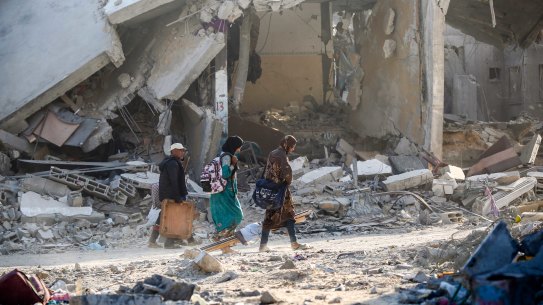 People inspect damage and remove items from their homes on Sunday after the IDF pulled out of Khan Younis.