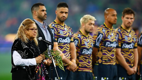 Aunty Joy Murphy performs a Welcome to Country before the round 12 game in 2022 as Storm players line up in their Indigenous jumpers for Indigenous Round. 