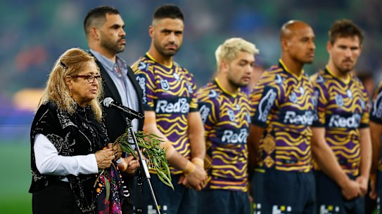 Aunty Joy Murphy performs a Welcome to Country before the round 12 game in 2022 as Storm players line up in their Indigenous jumpers.