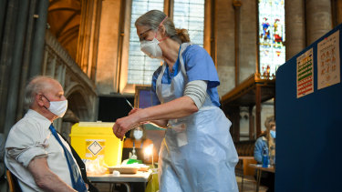 An English patient receives a dose of the Pfizer vaccine inside Salisbury Cathedral