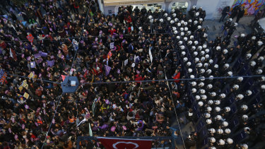 A phalanx of Turkish police officers in riot gear, right, block protesters during a rally in central Istanbul's Istiklal Avenue  to mark the United Nations' International Day for the Elimination of Violence Against Women on Sunday.