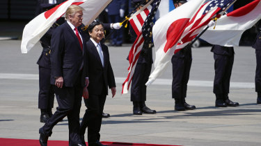 US President Donald Trump, left, is escorted by Japan's Emperor Naruhito.