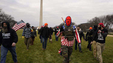 People march with those who claim they are members of the Proud Boys as they attend a rally in Washington.