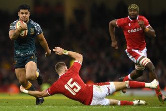 Wallabies centre Hunter Paisami skips past the tackle of Wales player Liam Williams .