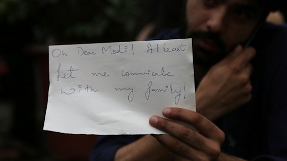 A Kashmiri, who works in Bangalore, holds a piece of paper addressing Indian Prime Minister Narendra Modi during a protest in Bangalore.