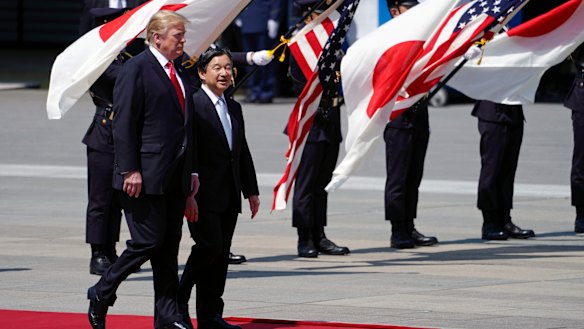 US President Donald Trump, left, is escorted by Japan's Emperor Naruhito.