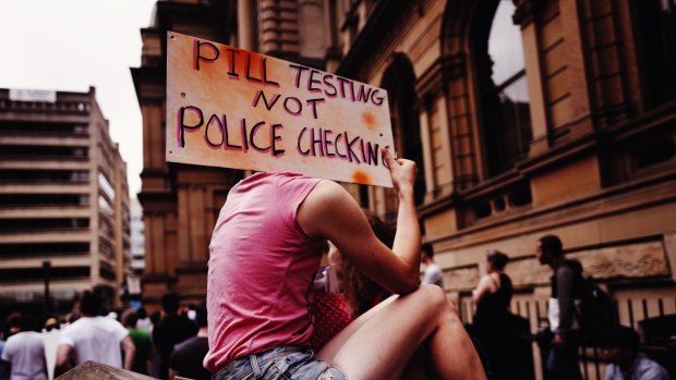 An attendee holds up a sign at a pill testing rally held at Sydney's Town Hall this year.