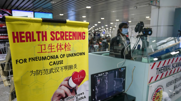 Health officials watch thermographic monitors at a quarantine inspection station at the Kuala Lumpur International Airport in Sepang, Malaysia.