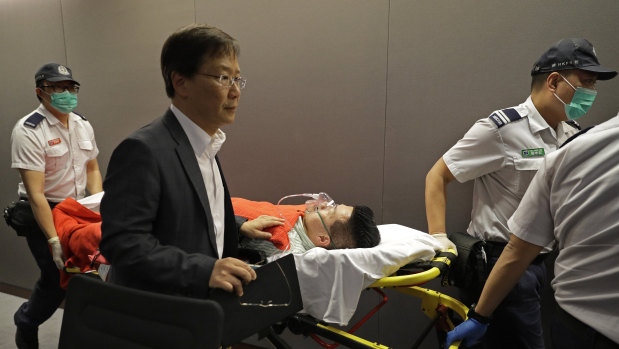 Pro-democracy lawmaker Gary Fan is carried on a stretcher after being injured in a clash with pro-Beijing lawmakers at a controversial amendments meeting in Hong Kong on Saturday.