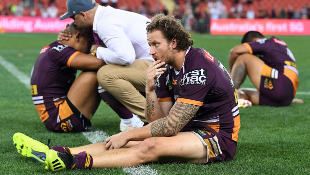 Dejected Broncos players slump to the ground after full-time.