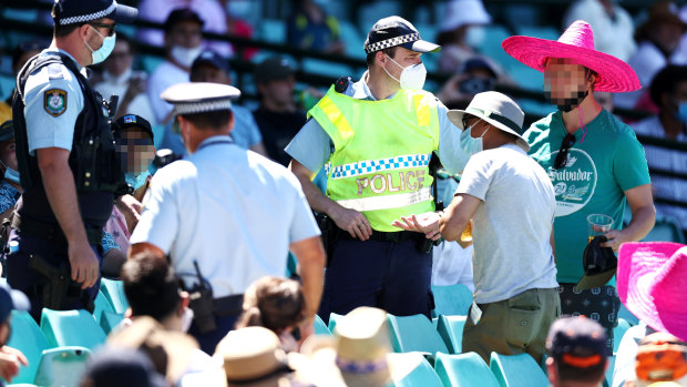 Prateik Kelkar (grey shirt) remonstrates with police after spectators were ejected from the SCG. 