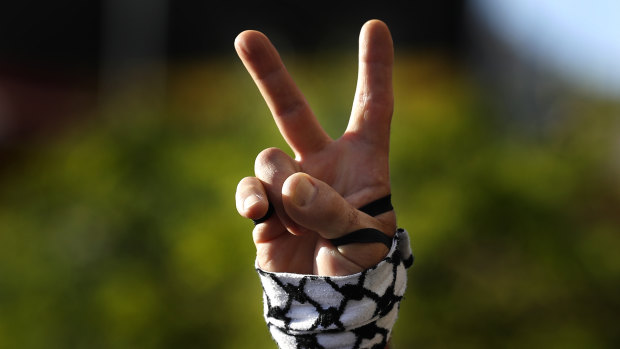 A protester flashes a victory sign  during a protest in support of Palestinians in the latest round of violence between Palestinians and Israelis, in Beirut, Lebanon.