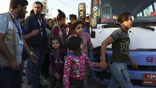 A group of Syrians disembark from one of the buses that brought  hundreds of refugees to Bardarash refugee camp in Iraqi Kurdistan. 