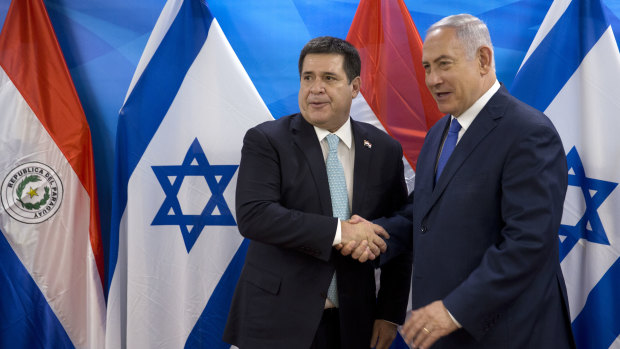Israeli PM Benjamin Netanyahu, right, shakes hands with Paraguayan President Horacio Cartes. Paraguay opened its new embassy in Jerusalem on Monday local time.