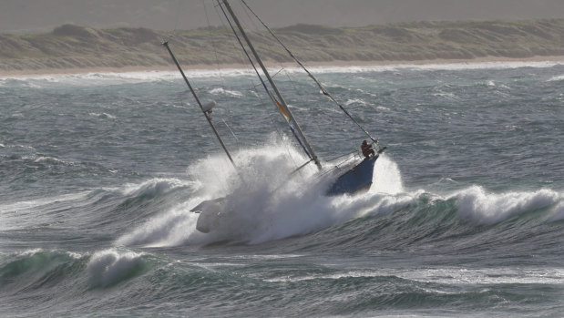 A crew member struggles to stand on the out-of-control yacht.