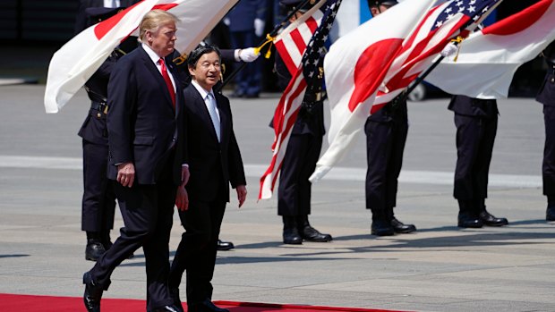 US President Donald Trump, left, is escorted by Japan's Emperor Naruhito.