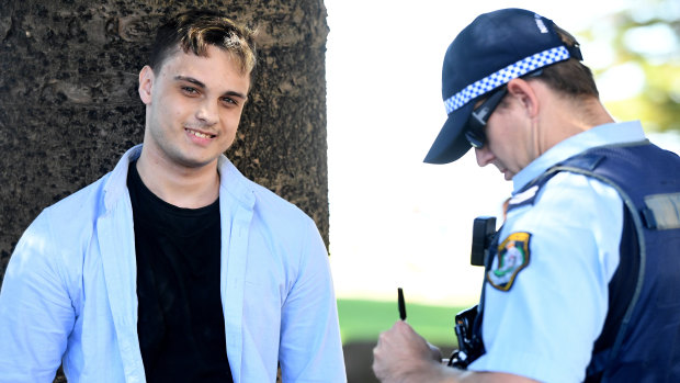 NSW Police detain a man after a confrontation with a photographer following a press conference.