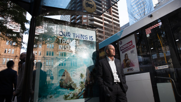 JCDecaux CEO, Steve O'Connor, next to a bus stop and buses displaying their advertising, in Sydney.