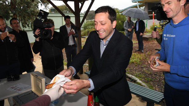 Hold the onions: Matthew Guy has a democracy sausage on Saturday after voting earlier in the week.