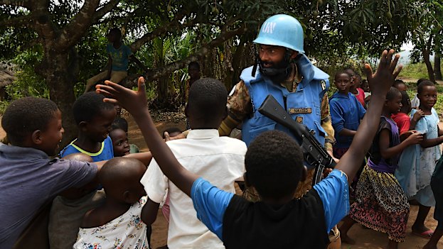 A United Nations peace keeper from Pakistan shakes hands with children while on patrol in a village near Kananga in Kasai Central. 